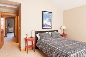 A bedroom with a bed, a nightstand, a lamp, and a poster on the wall. - Private Reserve 3 Bedroom Townhouse by RedAwning (Hood River)