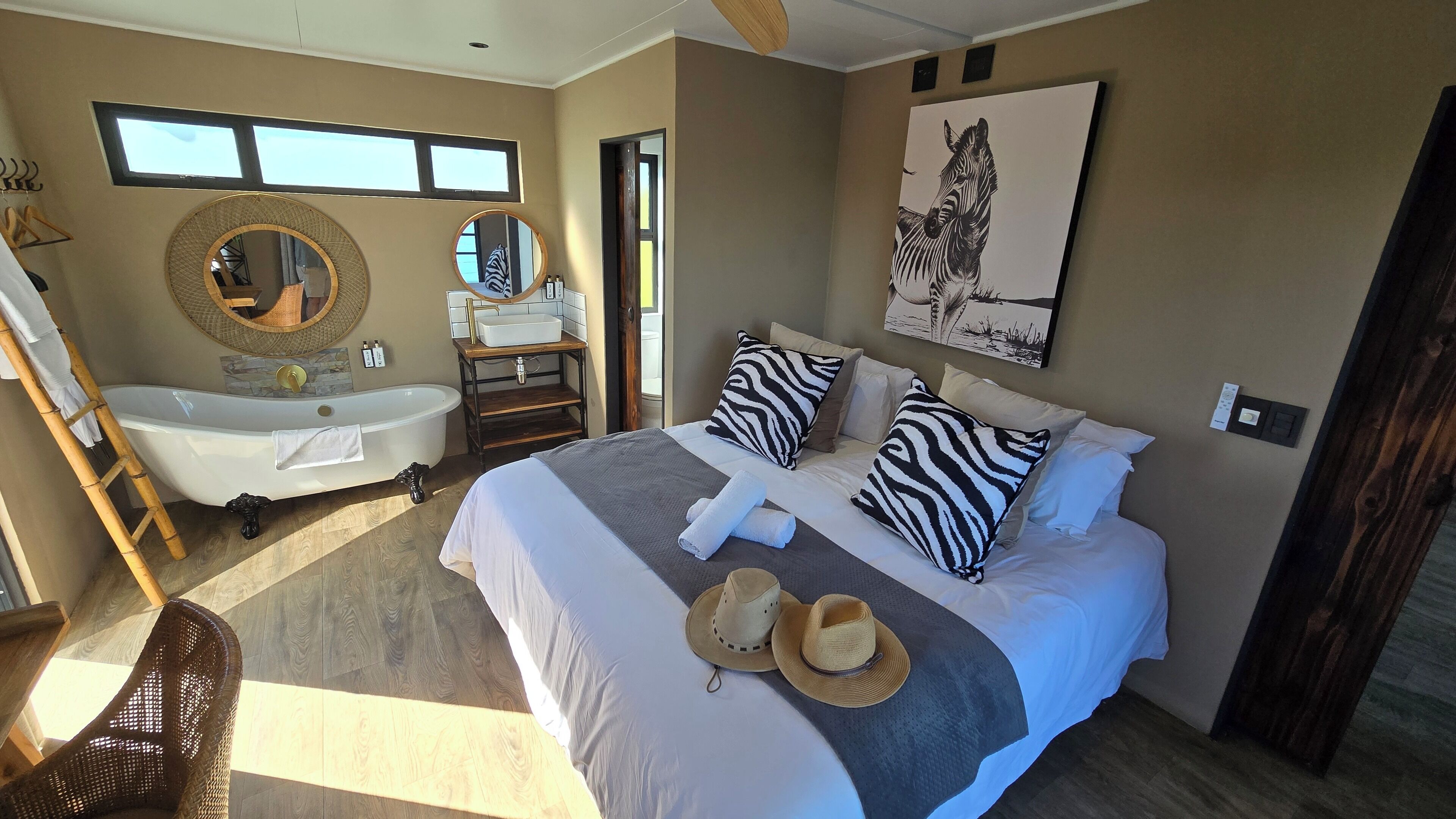 A bedroom with a large bed, a bathtub, and a window.