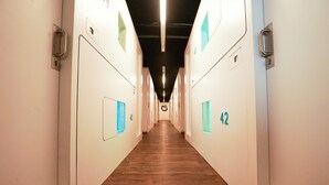 Un pasillo largo y estrecho con puertas numeradas 40 y 42, suelo de madera y paredes blancas.