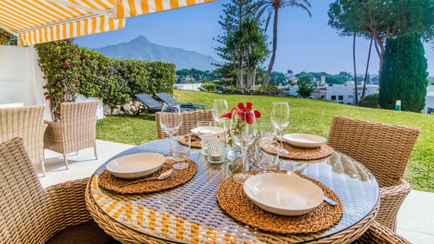 An outdoor dining area with wicker furniture and a view of mountains. - Azahara Marbella - Modern decorated apartment with lovely terrace view (Marbella)