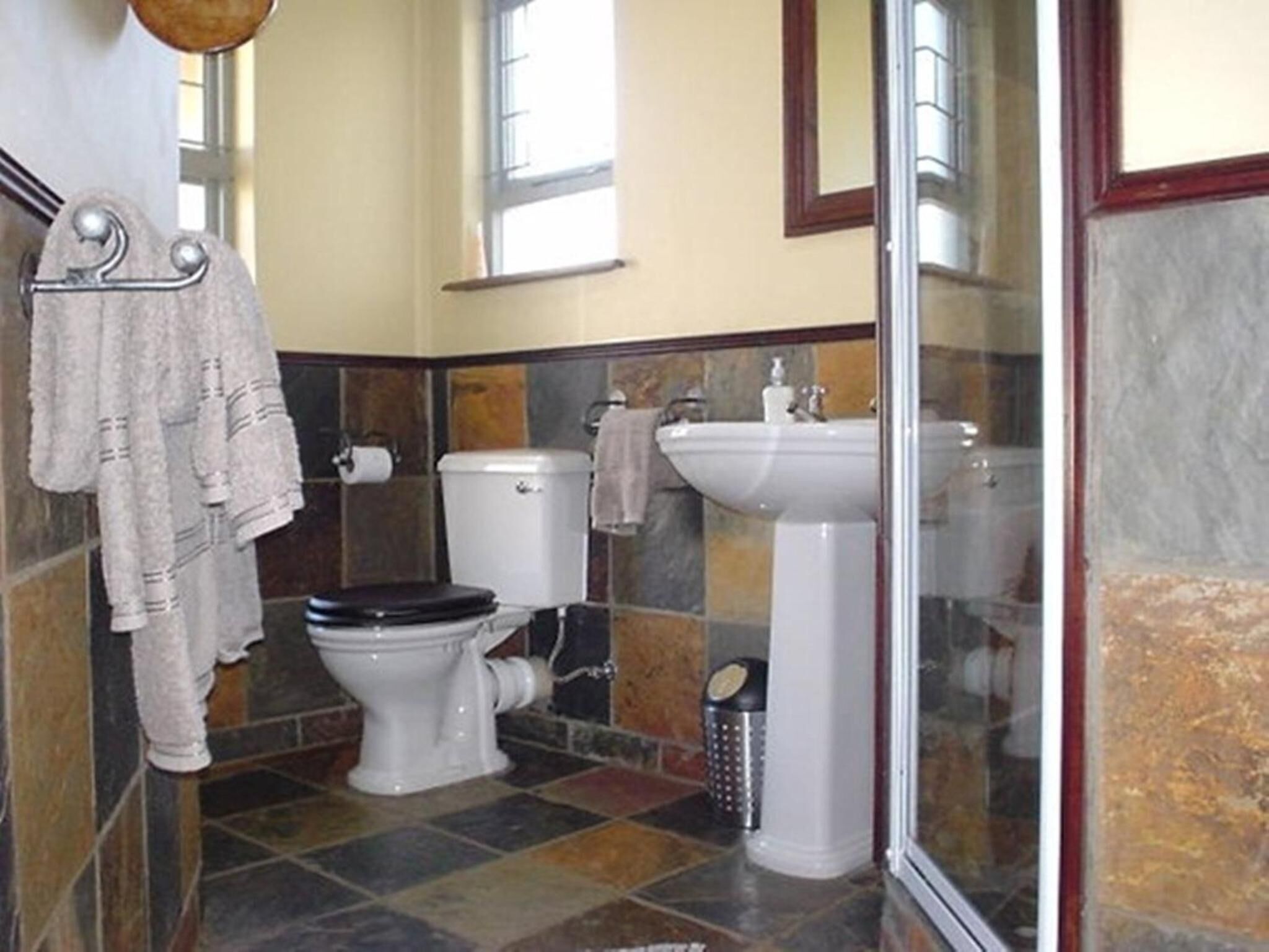 A bathroom with a toilet, sink, and shower area.