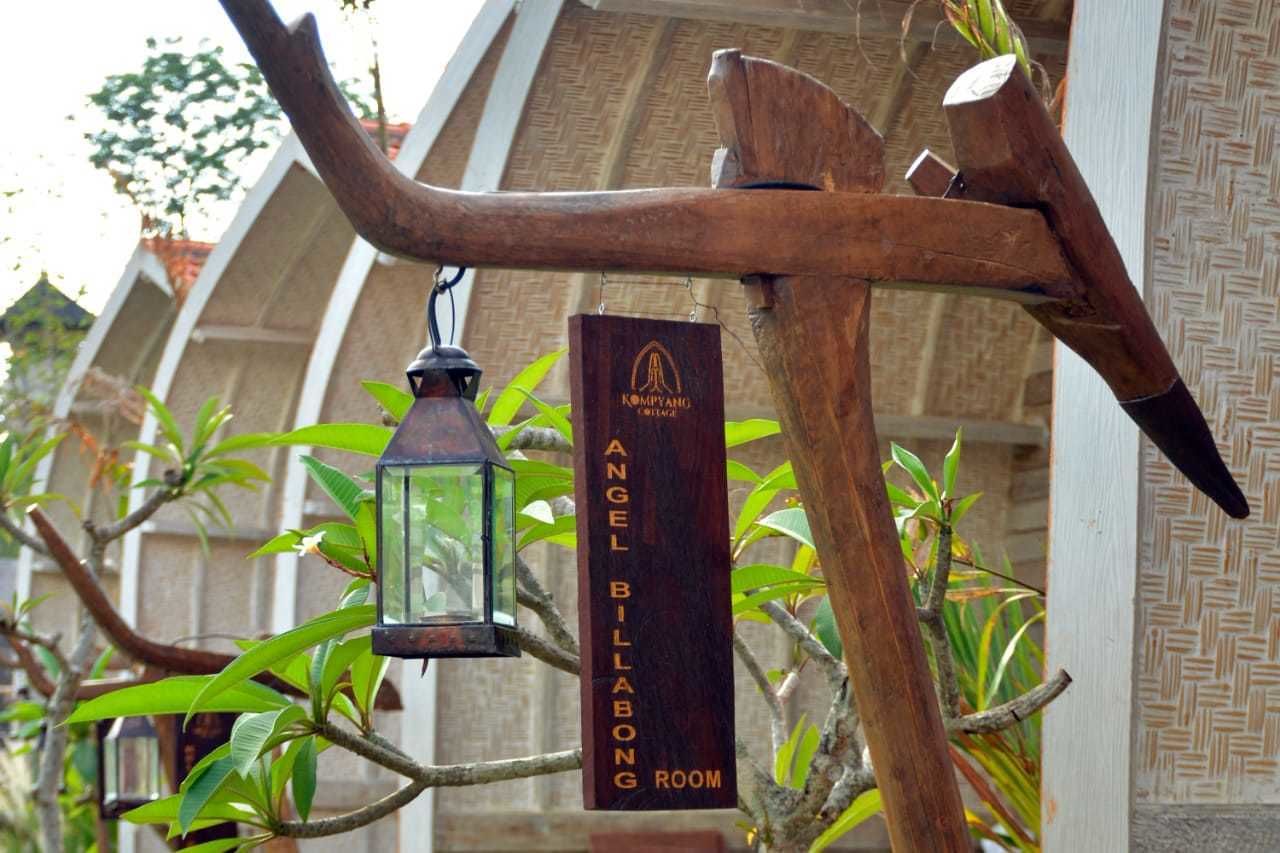 Uma estrutura de madeira com uma placa que diz 'Angel Billabong Room' e um lanterna pendurada.