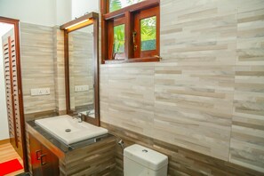A modern bathroom with a rectangular sink, a mirror, and a toilet. - Heaven in Satin Woods Rekawa (Rekawa)