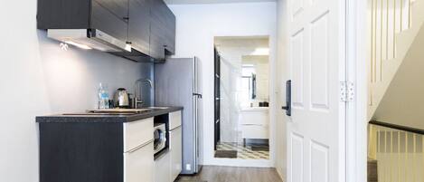 Een koelkast, een microgolfoven, een kookplaat, een waterkoker