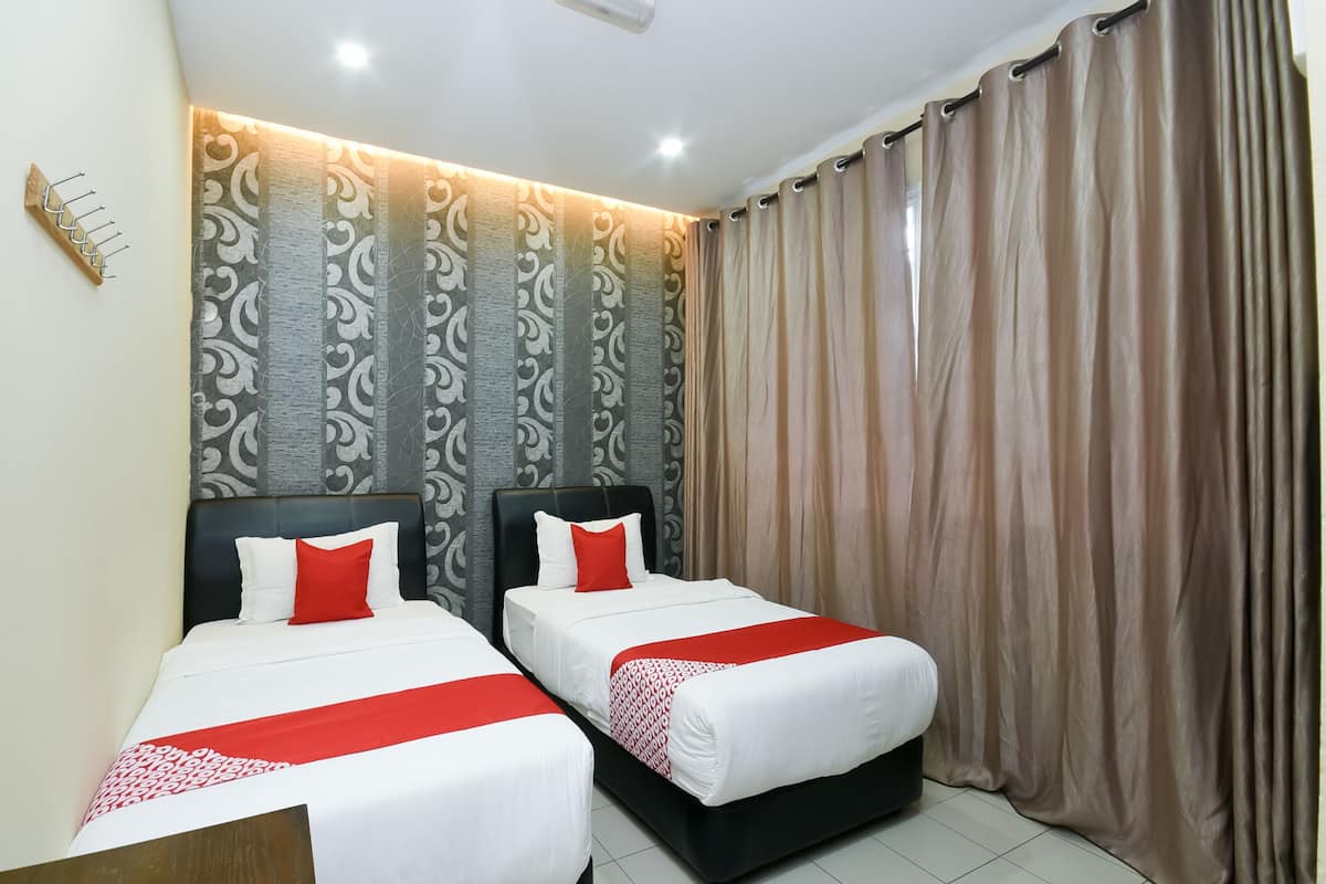 Quarto de hotel com duas camas, um papel de parede estampado e uma cortina.
