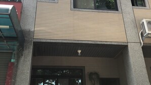 A multi-story building with air conditioning units, large windows, and a balcony. - Yi Jia Homestay (Jinning)
