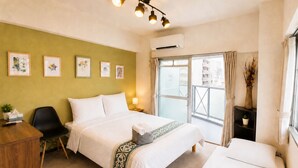 A hotel room with a bed, a desk, a chair, a window with curtains, and wall art. - COCO Fukuoka Chiyo (Fukuoka)