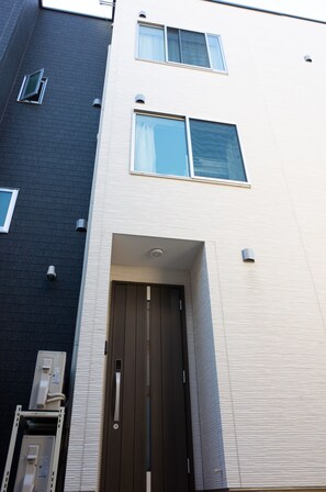 A multi-story building with a dark facade and a lighter upper section. - LcHotel&Stay 2A (Tokyo)