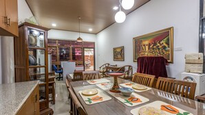 Un coin repas avec une table en bois dressée pour six personnes, entourée de chaises.