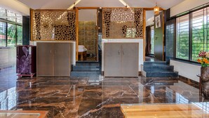 Eine moderne Lobby mit Marmorboden, einer Rezeption und einer Treppe zu den oberen Etagen.
