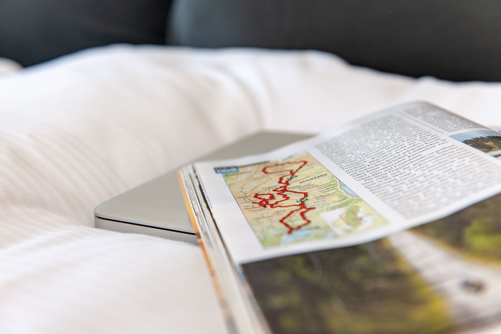 A magazine with a map on a bed.