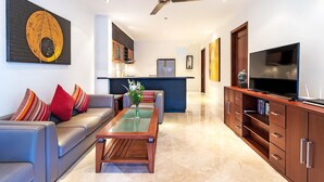 A modern living room with a sofa, coffee table, and TV stand. - Villa Lalang Temu (Jimbaran)
