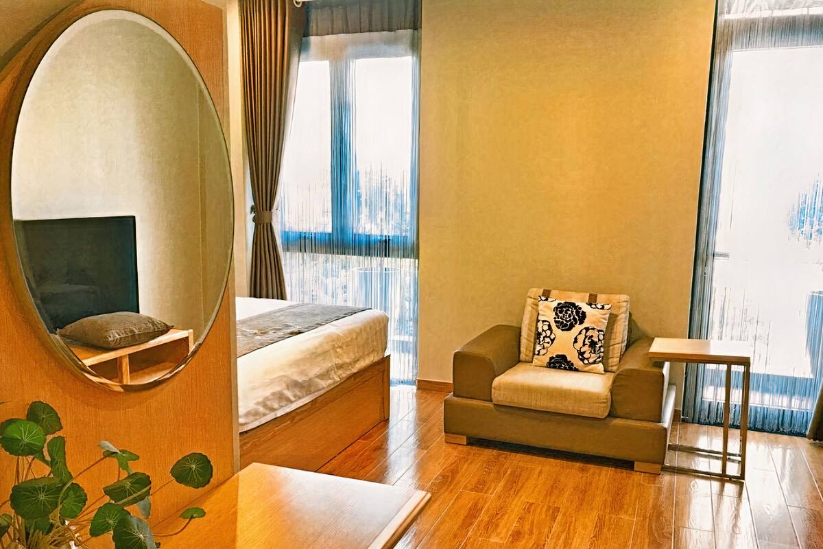 Ein modernes Hotelzimmer mit einem Bett, einer Couch, einem kleinen Tisch und einem Spiegel.