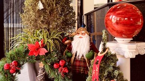 A festive indoor setting with a Christmas tree, poinsettia, and a Santa Claus figure. - F&F Hotel (Hai Phong)