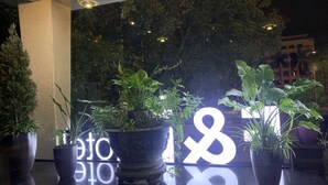 A reception area with potted plants and a large illuminated sign. - F&F Hotel (Hai Phong)