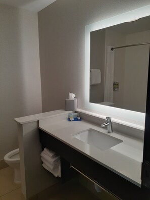 A bathroom with a white sink, a mirror, a towel rack, and a toilet.