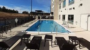 A rooftop pool area with lounge chairs, a pool, and a building with multiple windows. - Holiday Inn Express Richburg by IHG (Richburg)