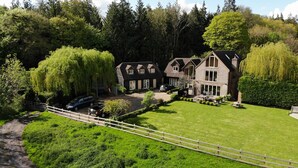 A large, two-story house with a well-maintained lawn and a fence. - The Apartments Quidhampton Mill (Salisbury)