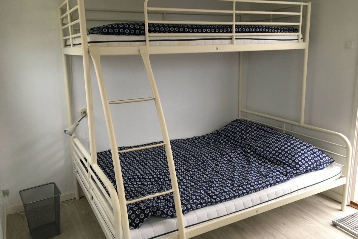 Ein Etagenbett mit gemustertem Lattenrost und einer Stehle.