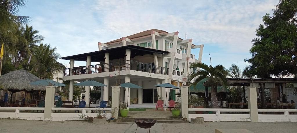 Un edificio de varios pisos con balcones, mobiliario exterior y plantas en macetas.