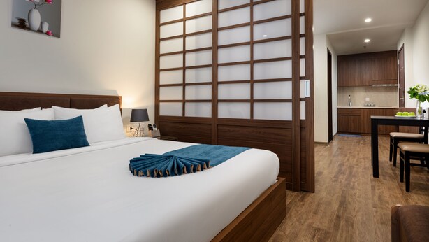 Une chambre d’hôtel avec un lit, un bureau et une kitchenette.