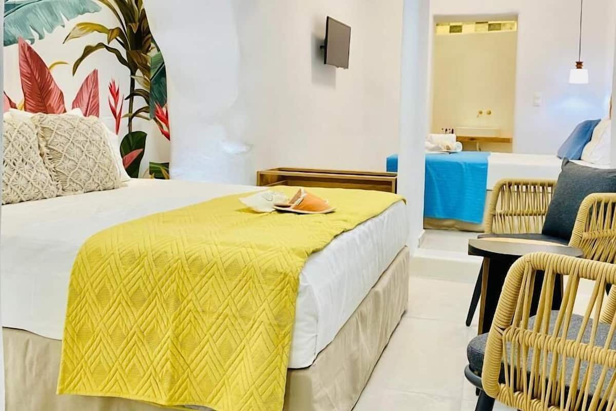 A hotel room with a bed, a desk, and a chair.