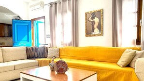 A living room with a yellow sofa, a beige sofa, and a wooden coffee table.