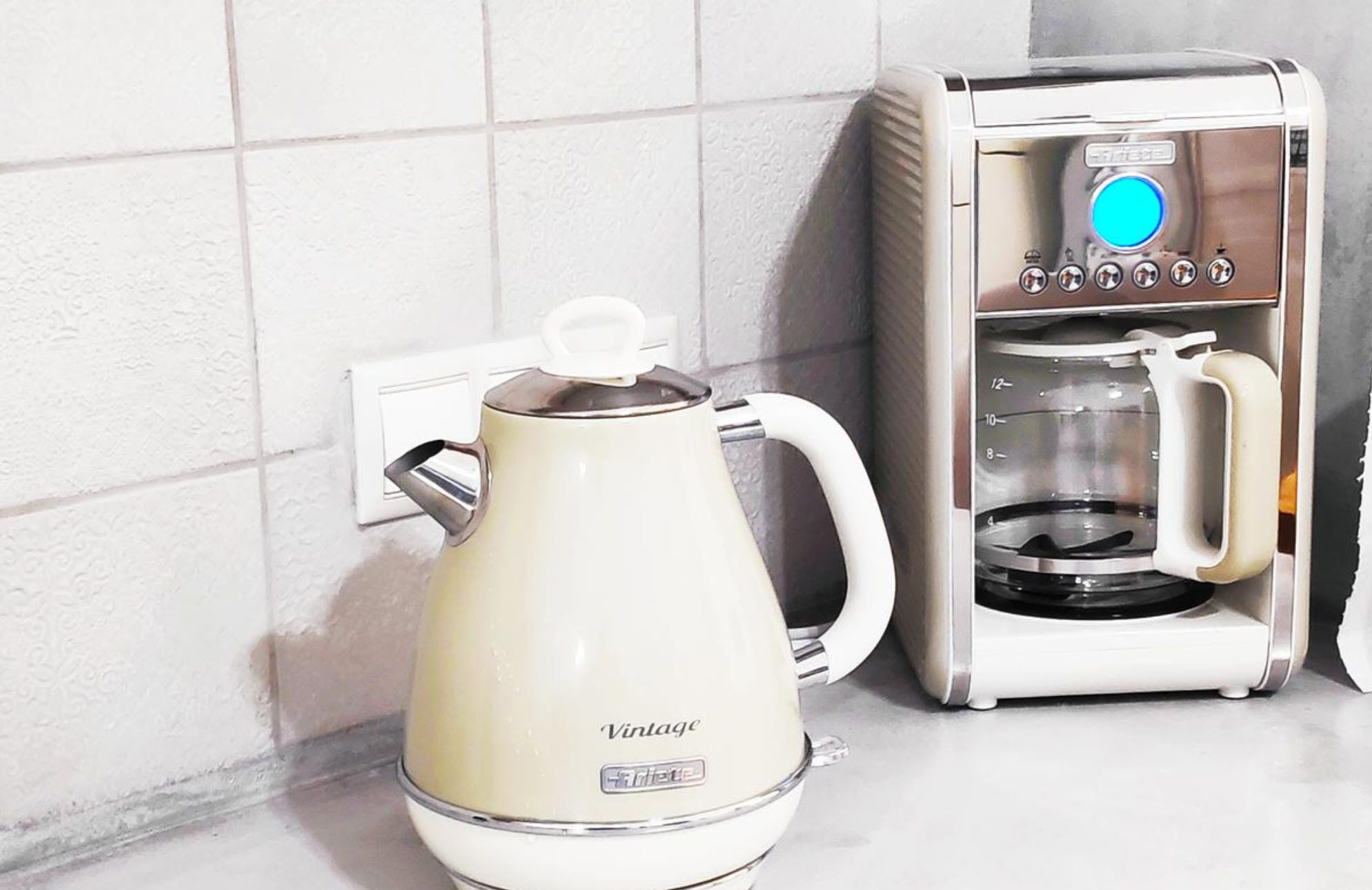 Een retro koffiezetapparaat en een koffiemachine op een aanrecht.
