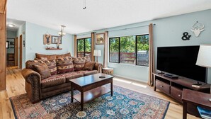 Ein Wohnzimmer mit Sofa, Couchtisch, Fernseher und Deckenventilator.