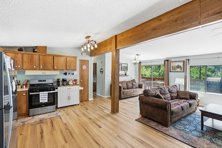 A spacious kitchen with wooden cabinets, a built-in oven, and a dining area with a sofa and table.