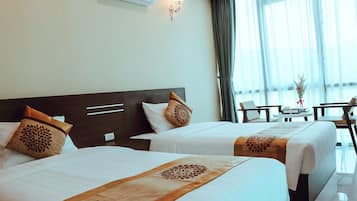 A hotel room with two beds, a desk, and a chair.