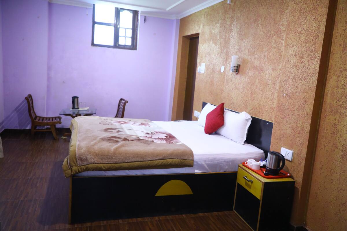 A bedroom with a bed, a nightstand, a chair, and a small table.