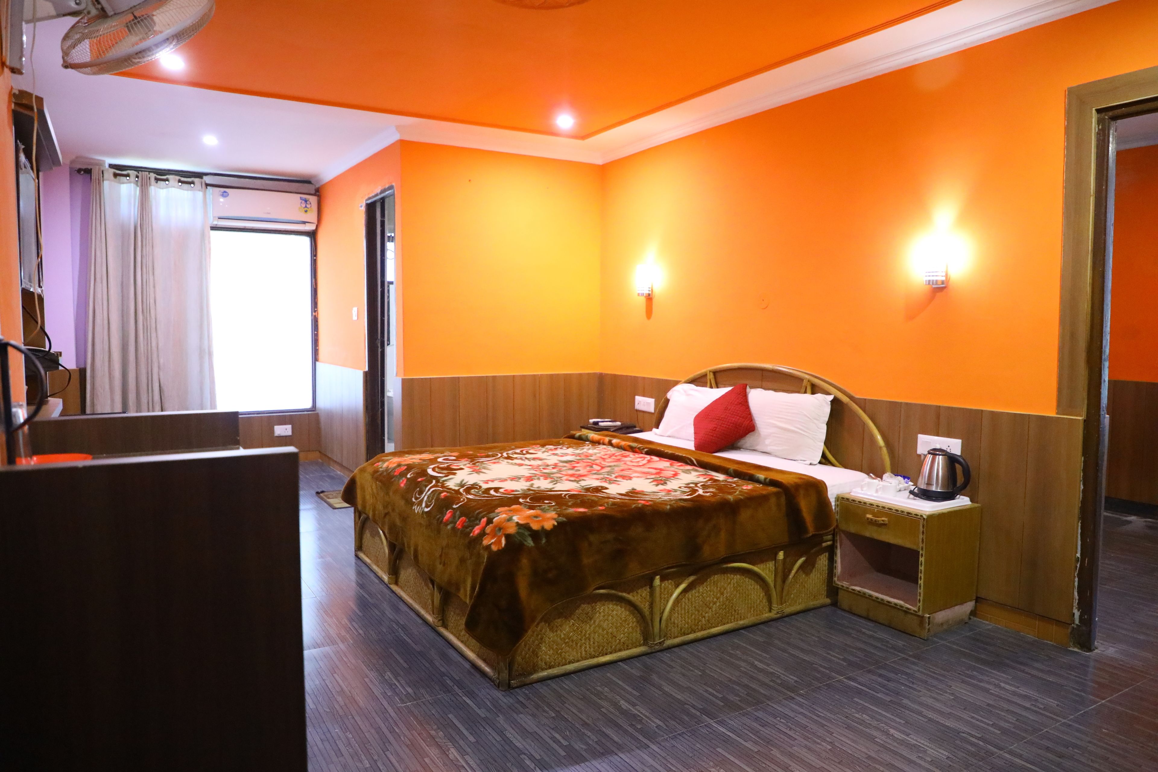 A hotel room with a bed, bedside table, and a nightstand.