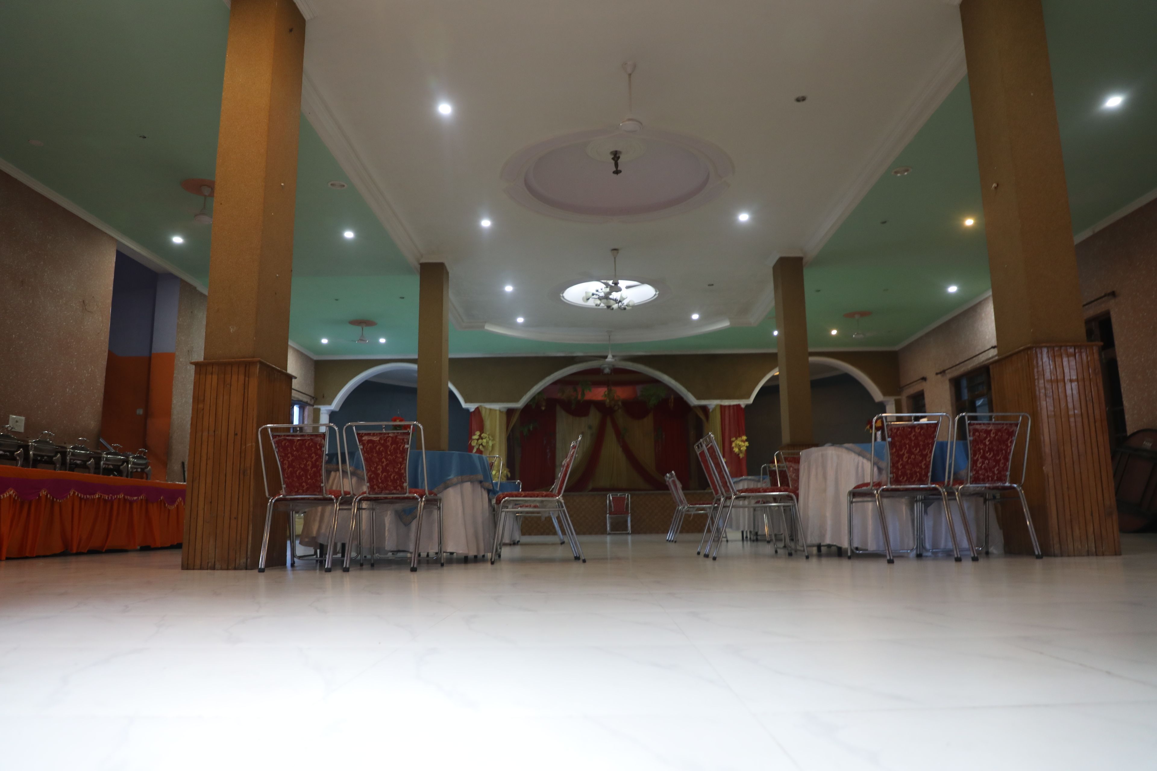 A spacious hall with high ceilings, multiple chandeliers, and rows of chairs.