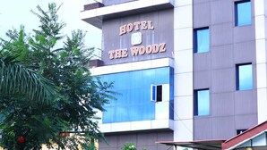 Un moderno edificio de hotel con el letrero "HOTEL THE WOODZ" bien visible.
