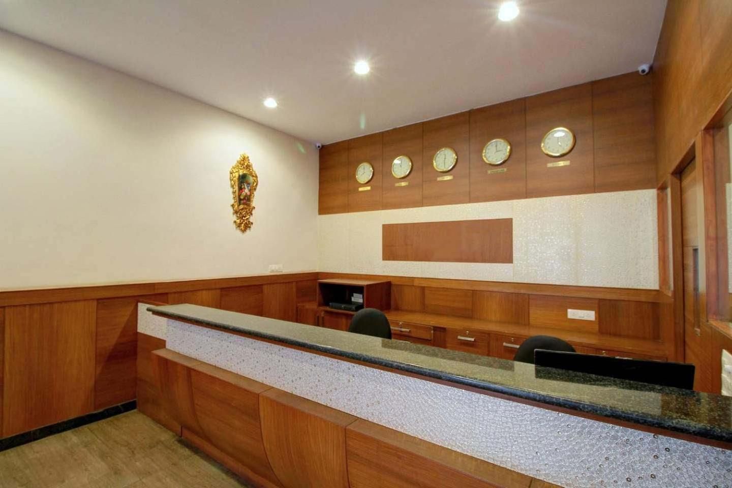 A reception area with a long counter, wooden paneling, and a wall-mounted clock.