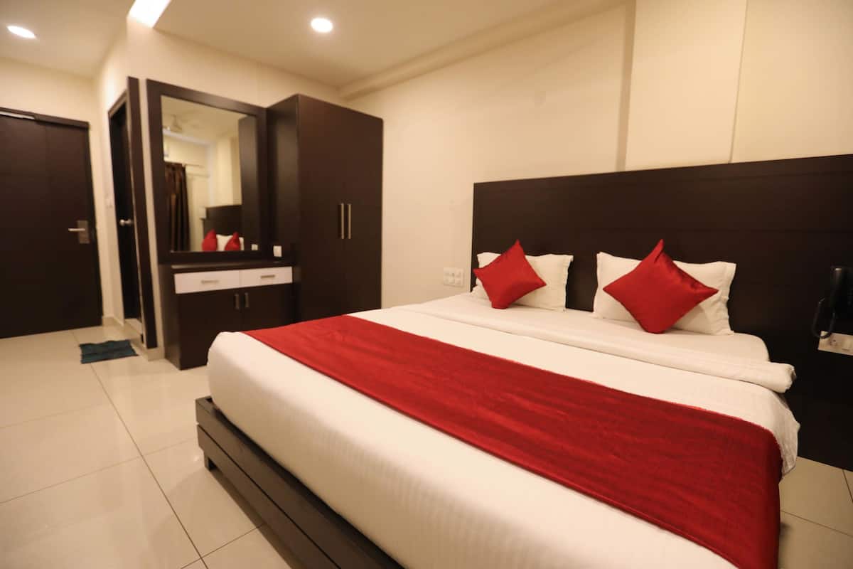 Una habitación de hotel con una cama grande, un armario, un espejo y un baño.