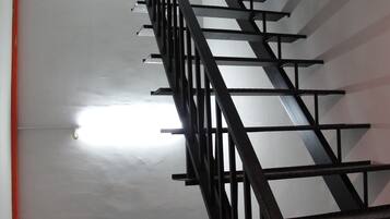 A staircase with a metal railing and a red trim at the base.