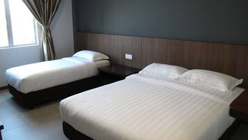A hotel room with two beds, a wooden headboard, a window with curtains, and a tiled floor.