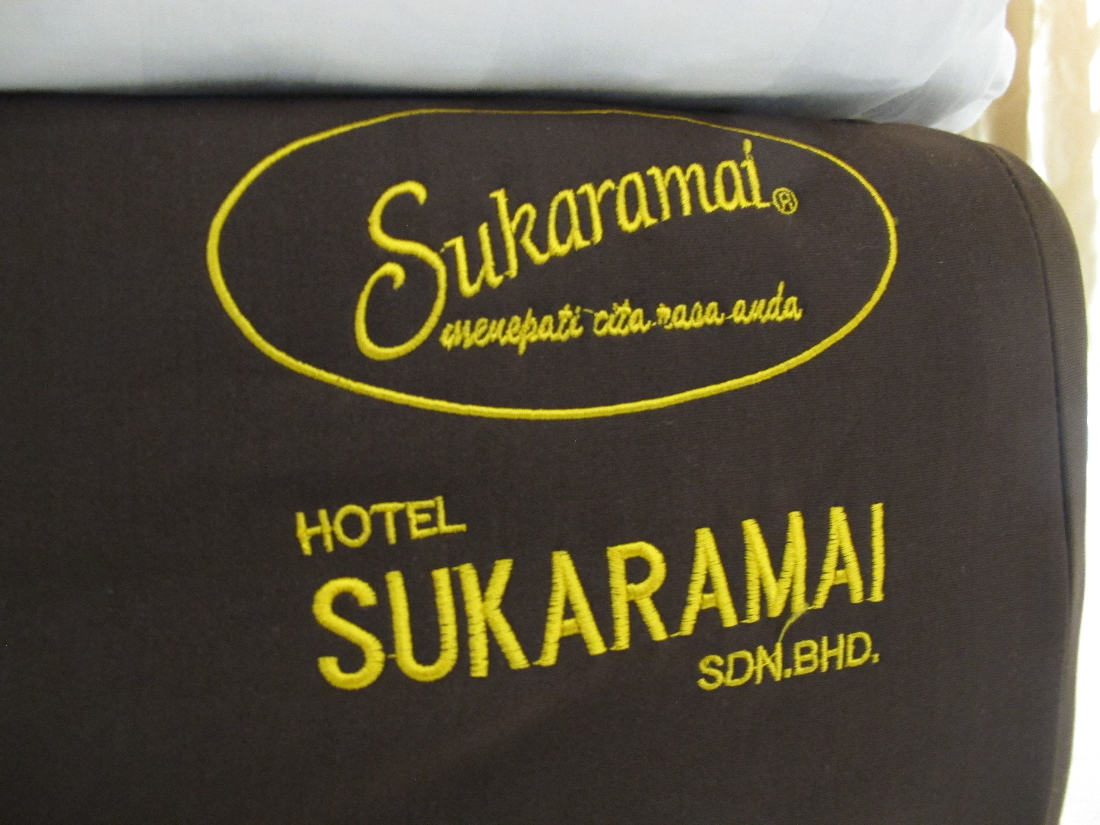 A pillow with the logo and name of Sukaramai Hotel, indicating it is a branded hotel.