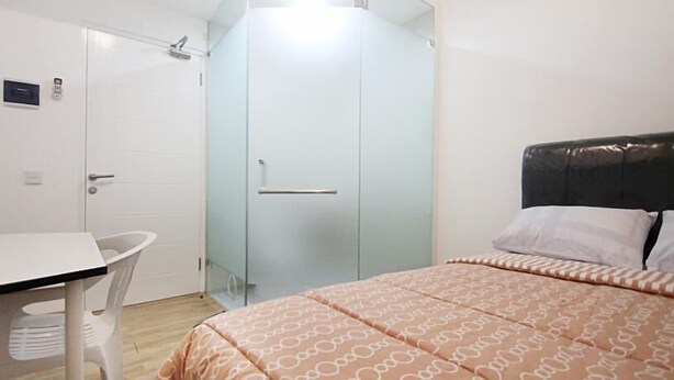 A bedroom with a bed, a desk, and a wardrobe. - Rumah Kayu Manis Tebet (Jakarta)