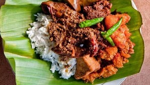 A plate of food with rice, meat, and vegetables on a banana leaf. - Rumah Kayu Manis Tebet (Jakarta)