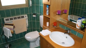A bathroom with a white toilet, a sink, a mirror, and a towel rack. - Gästezimmer Lußhardthof (Sankt Leon-Rot)