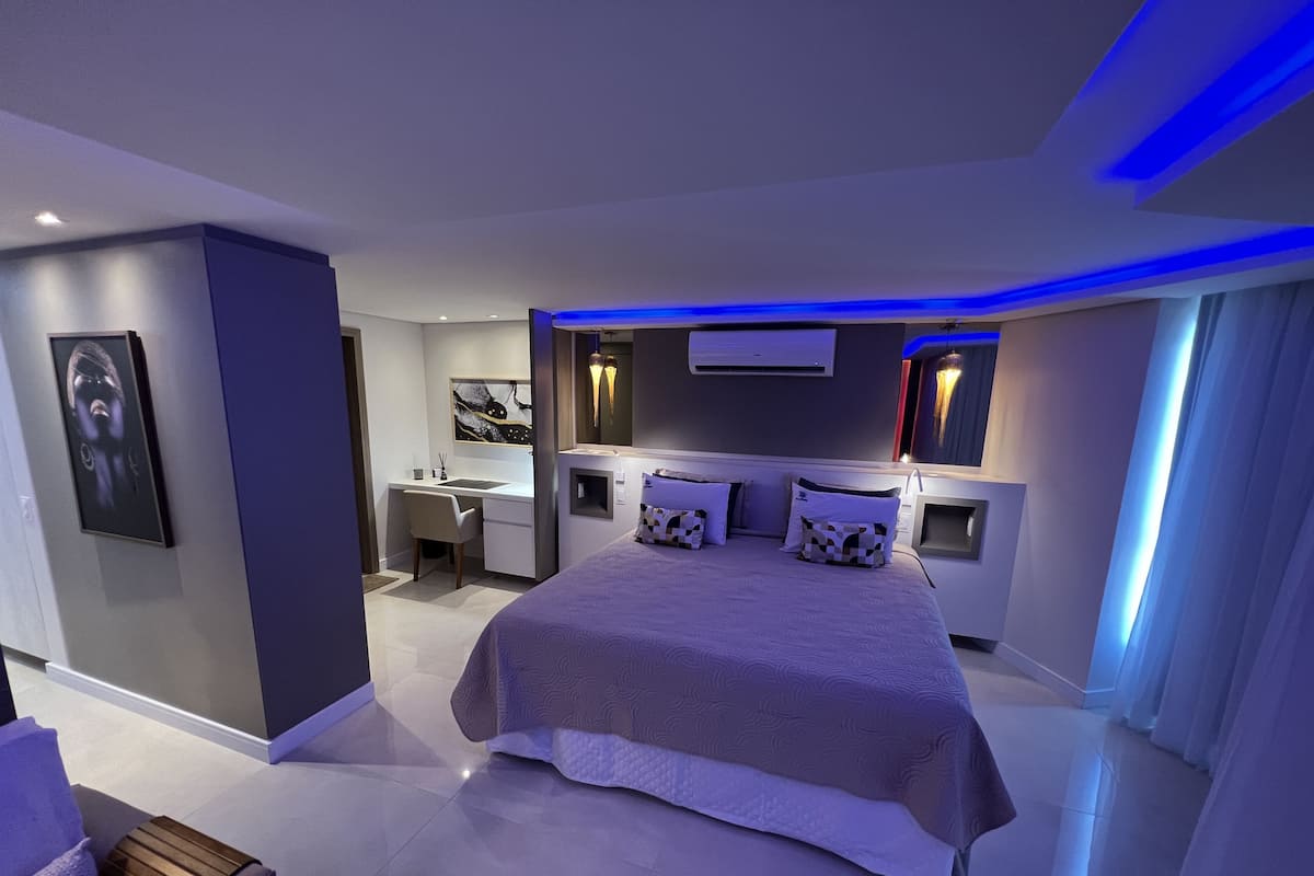 Un dormitorio moderno con una cama grande, un escritorio y una silla.
