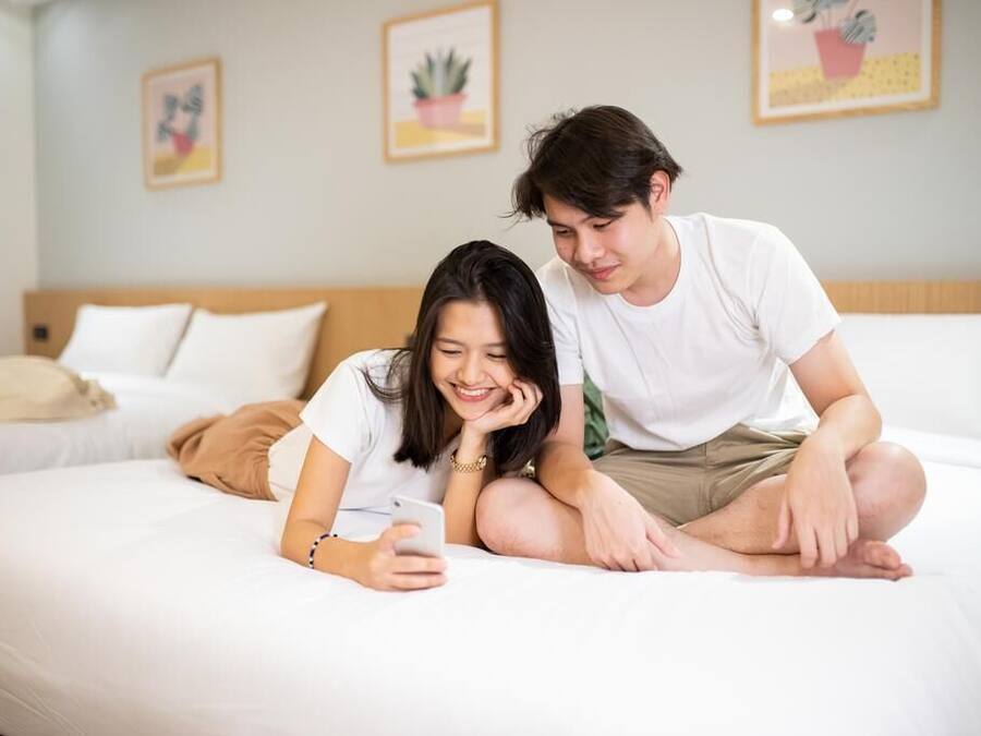 A bedroom with a bed, pillows, and a bedside table.