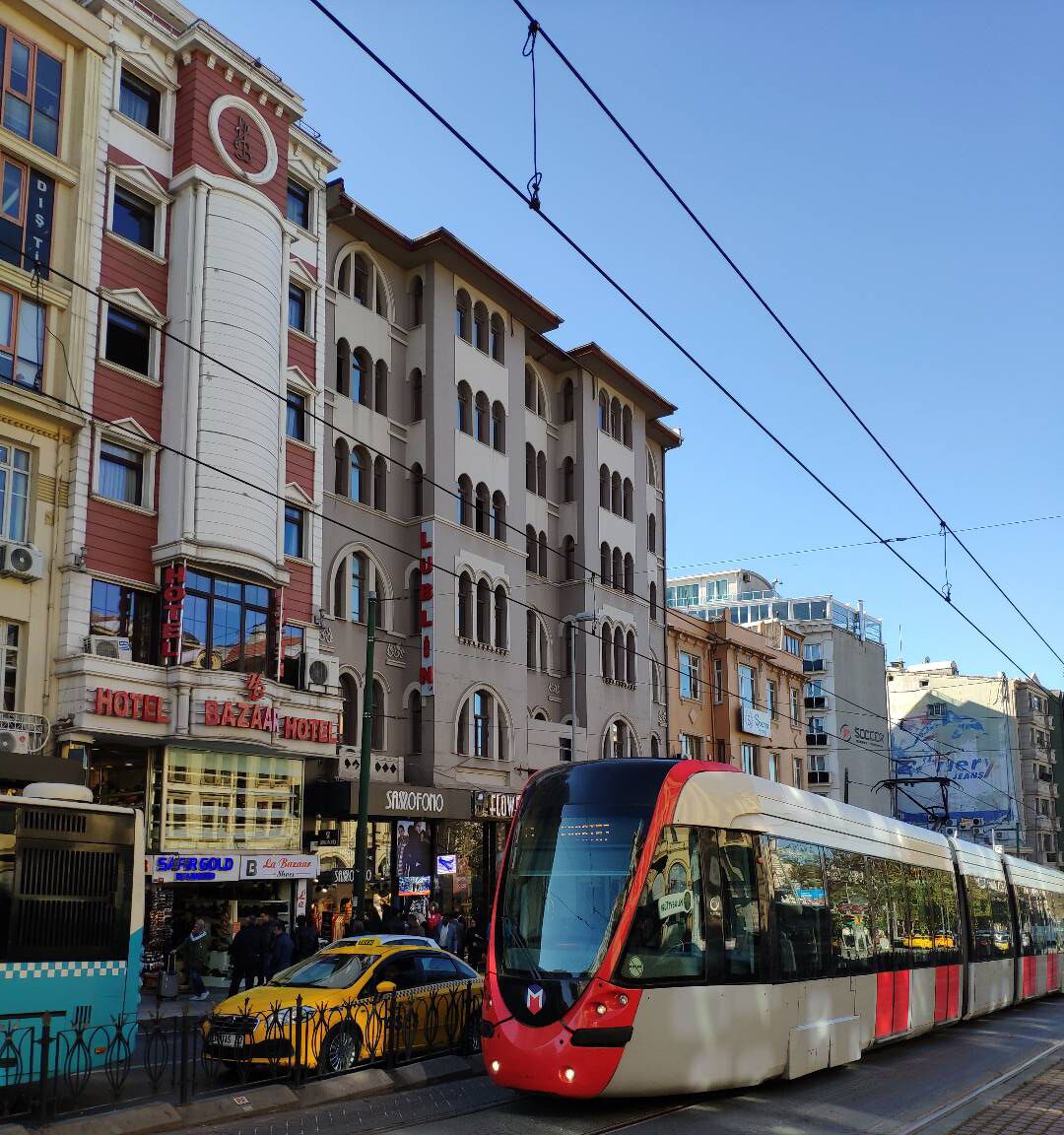 A tram on a city street with buildings in the background.