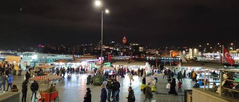 A bustling nighttime market with people walking and vendors selling goods.