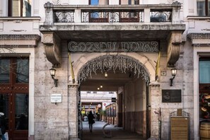 Entrada de un edificio histórico con el nombre 'Gozdu Udvar' sobre un arco decorativo.