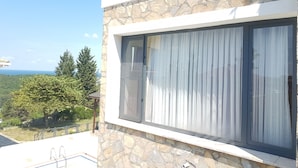 A modern building with a stone facade, large windows, and a balcony with metal railings. - Ağva Stone House Boutique (Sile)