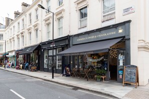 A street view of a row of shops including Formosa Street W9, Craft Beer, Wine Spirits, and Flowers - Chocolate - Gifts & Coffee. - Panoramic Family Home in Maida Vale (London)